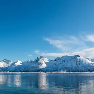 Steep, snowy mountains dropping straight into the ocean